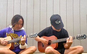 Sister and brother practicing guitar